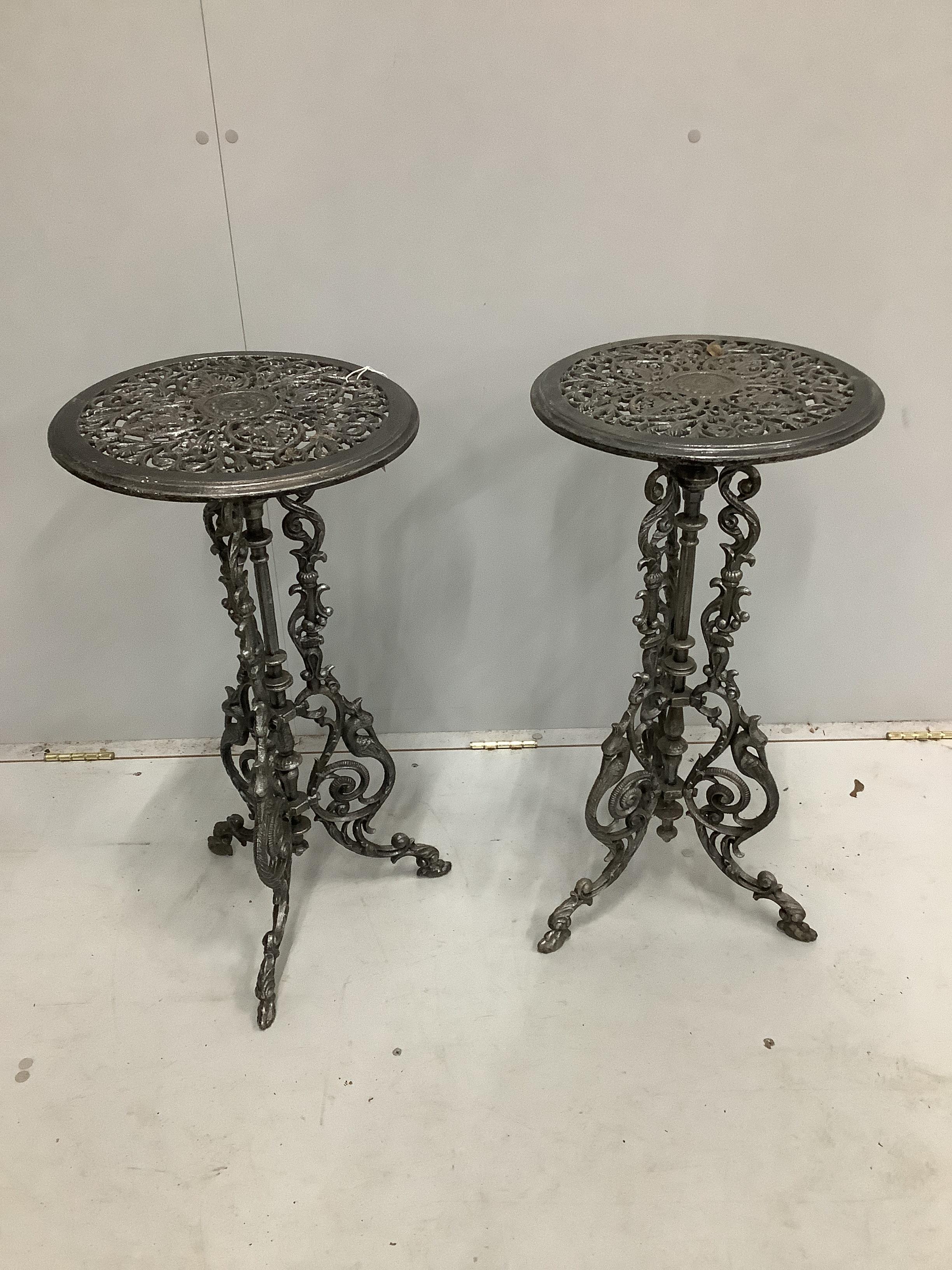 A pair of Victorian style circular cast metal tripod tables, diameter 36cm, height 72cm